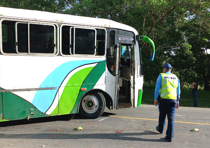 Policía observa el bus que se le desprendieron las llantas. 