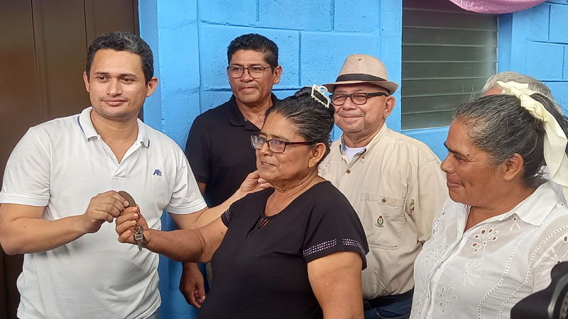 El licenciado Natividad Chavarría, entrega las llaves de su nueva casa a una de las beneficiadas. 