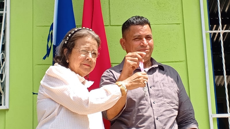 Alcaldesa de Juigalpa, licenciada María Estelbina Báez, le entrega las llaves de su nueva casa a Rolando Peralta. 