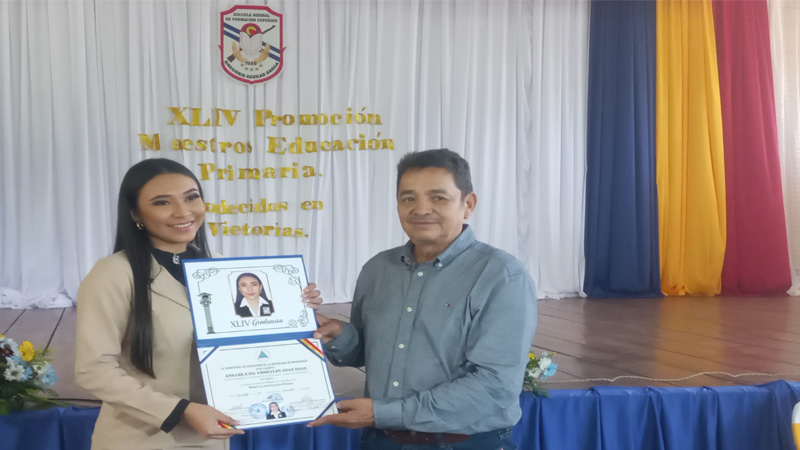 Licenciado Arístides Gómez Machado, entrega el título a una  nueva profesional de la educación. 