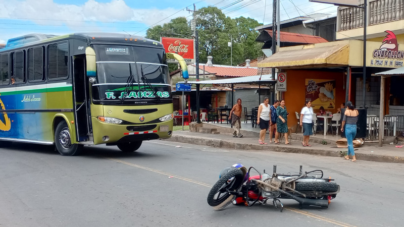 Motociclista sobre la raya que divide los carriles. 