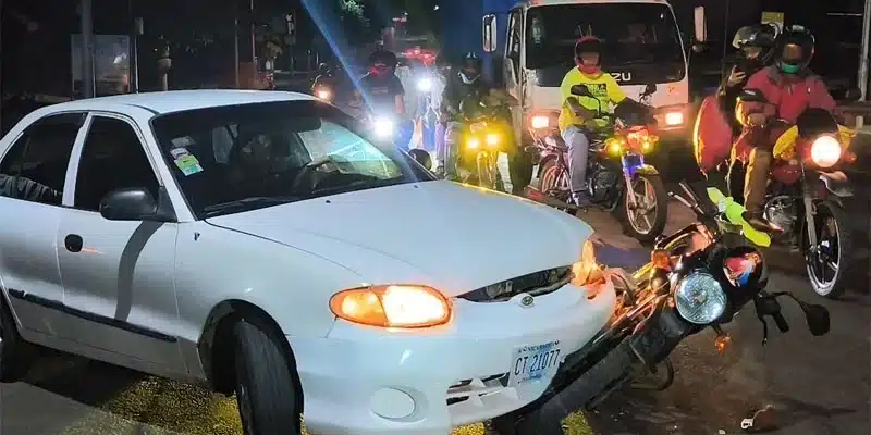 Motociclista ileso junto a su acompañante, luego de ser impactado por la conductora de un automóvil