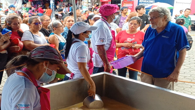 La gente retirando su porción de sopa de huevo de toro. 