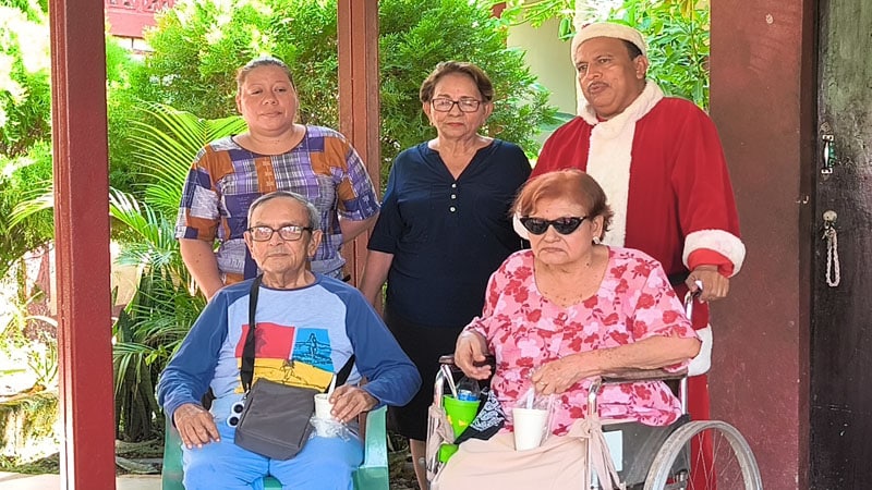 Santa Claus Nica junto a adultos del hogar y el personal de apoyo. 