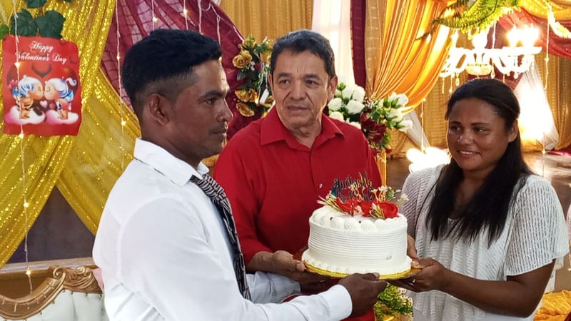 Licenciado Arístides Gómez Machado, entrega un queque a una pareja recién casada. 